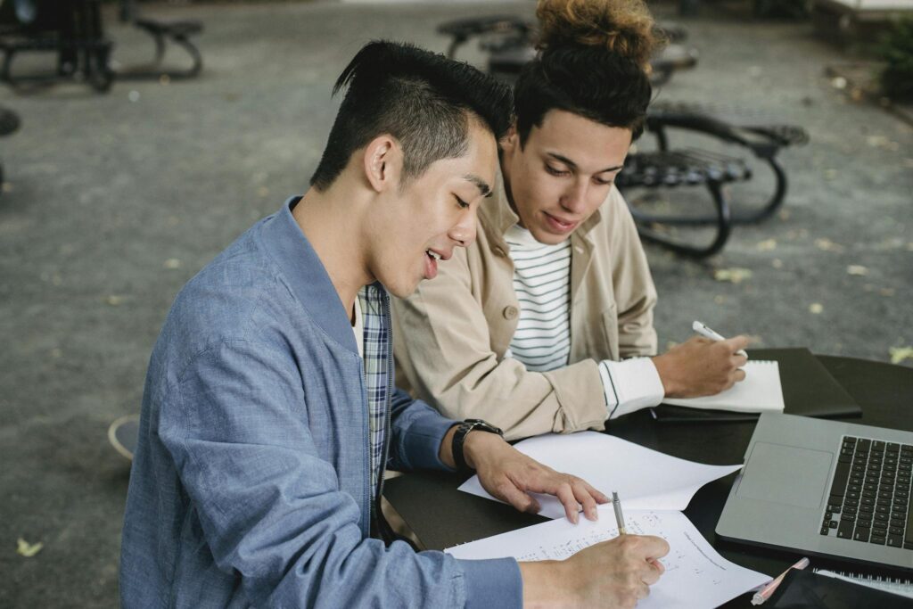 Multiethnic students doing homework together in park